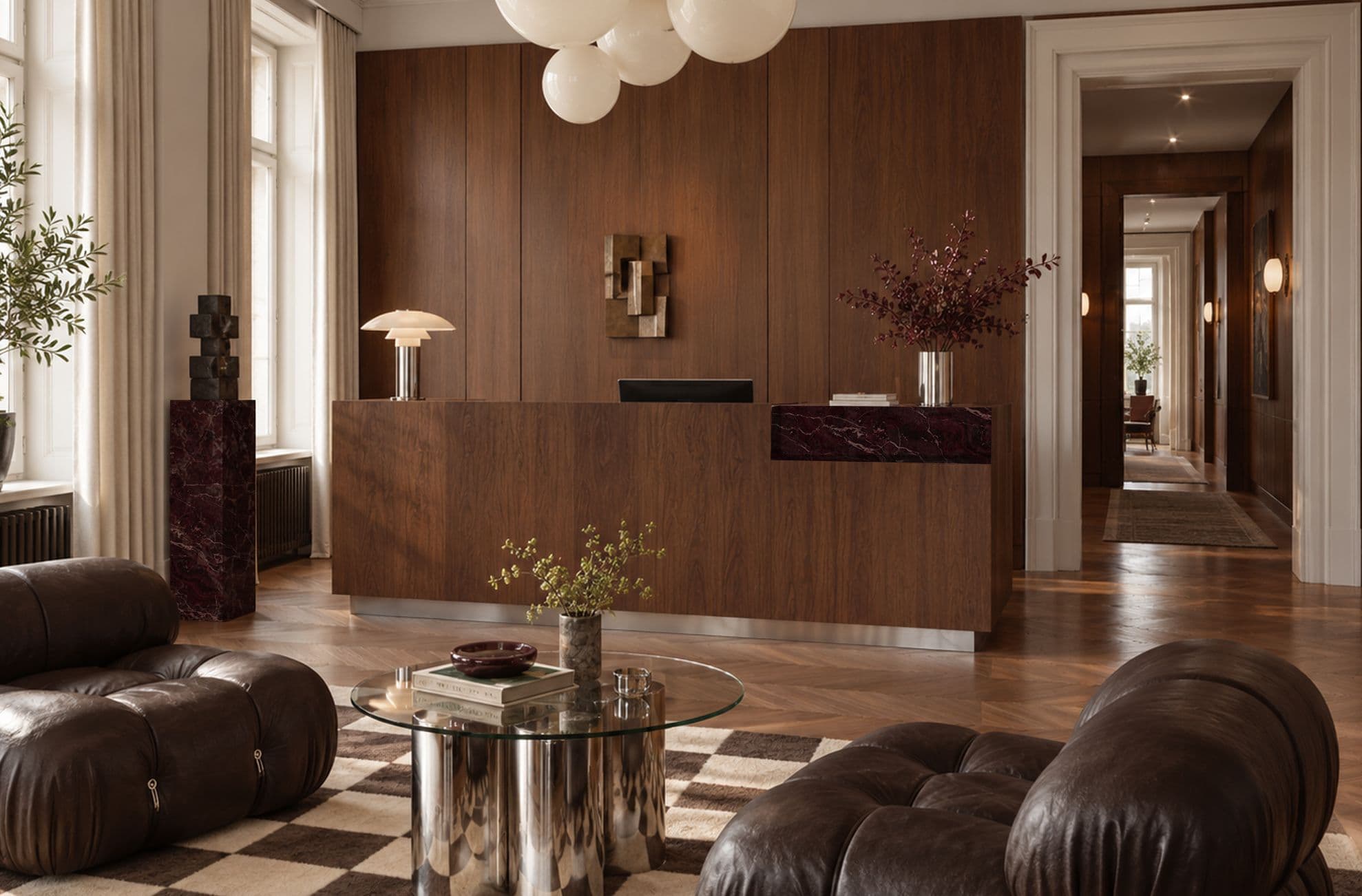 Walnut reception counter with a dark red marble inset on a steel plinth, in front of walnut wall panelling
